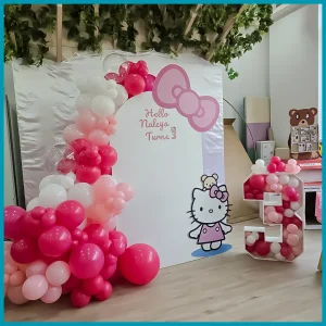 Hello Kitty birthday party decor setup in Dubai with pink balloon garland, backdrop, LED age number, and themed cutouts for kids celebration